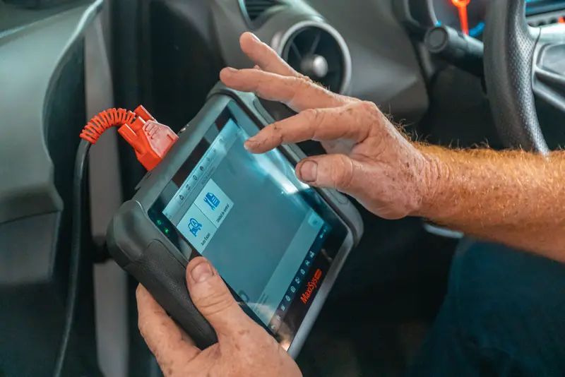 Računalni dijagnostički uređaj spojen na automobil prikazuje očitanje