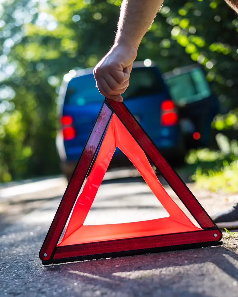 Vozač postavlja sigurnosni trokut na cestu iza zaustavljenog automobila